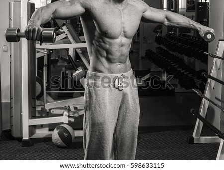 A very strong man is engaged in the gym