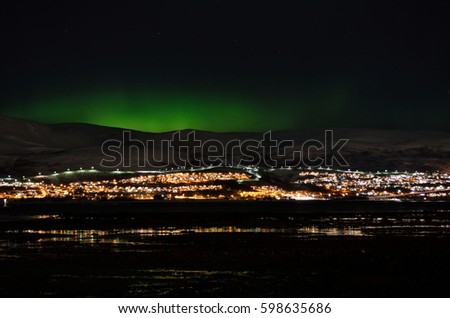 mighty northern light dancing over snowy mountain peak in northern norway on the whale island settlement