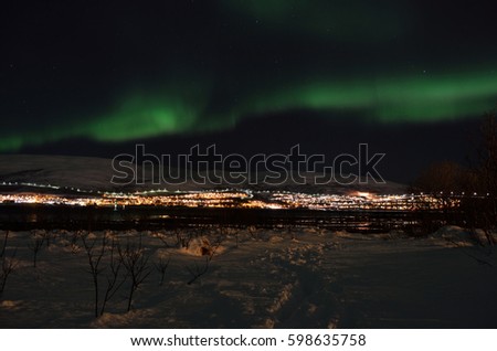 mighty northern light dancing over snowy mountain peak in northern norway on the whale island settlement