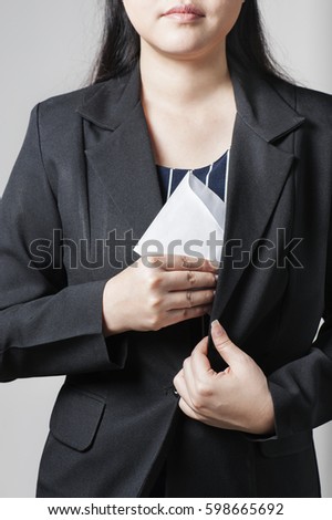 A businesswoman wearing a white envelope in her suit is bribing the concept of corruption in business activities.