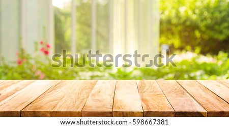 Empty wood table top on blur abstract green from garden and house in morning background.For montage product display or design key visual layout Royalty-Free Stock Photo #598667381