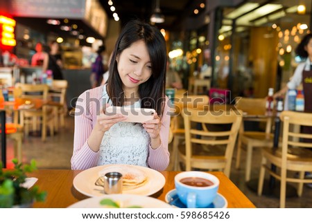 Woman taking photo on her dish