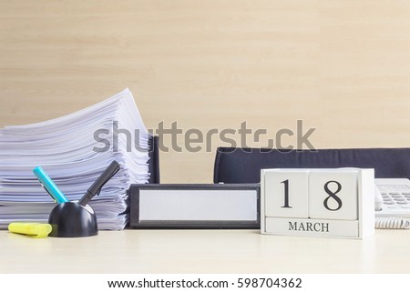 Closeup white wooden calendar with black 18 march word on blurred brown wood desk and wood wall textured background in office room view with copy space , selective focus at the calendar