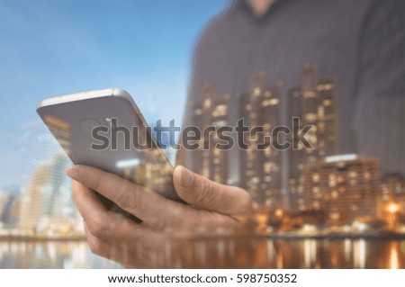 businessman using smart phone and at his workplace using technology, flare light , Double exposure businessman hand.
