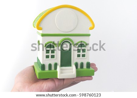 White and green house model on hand, white background