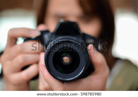  photographer covering her face with the camera.