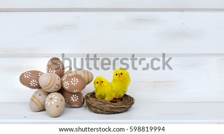 easter eggs and yellow chickens  on a white wooden background