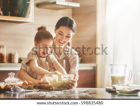 Happy loving family are preparing bakery together. Mother and child daughter girl are cooking cookies and having fun in the kitchen. Homemade food and little helper. Royalty-Free Stock Photo #598835480