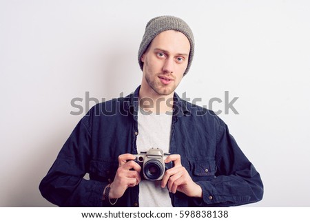 Portrait of a handsome young in hat man with camera