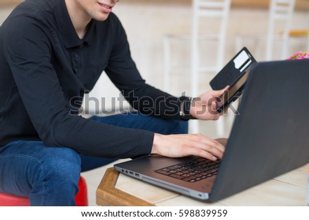 Man with computer shopping online.Under exposed photo