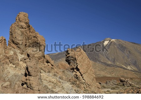 Teide volcano from the East with lava stone formations in foreground and against a blue sky, picture from Tenerife Spain.