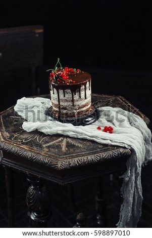 Chocolate cake with red currants on a table