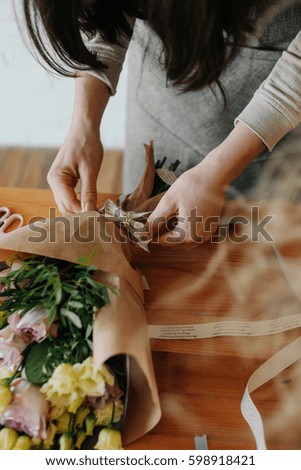 A woman florist collects a bouquet