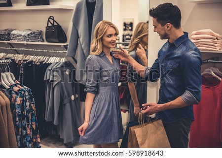 Beautiful couple is smiling while doing shopping in the shopping mall