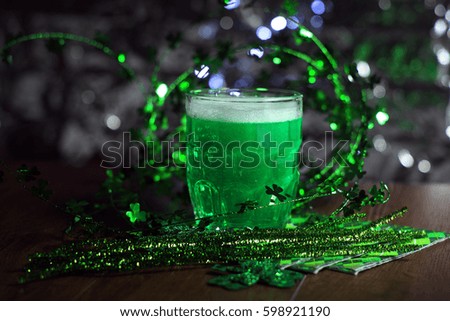 St patricks day. Beautiful background for St. Patrick's day with a glass of green beer. Glass of green beer with clover leaves on wooden table. . Patricks Day decorations with green beer.