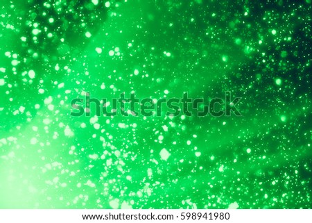 Green abstract background. Bokeh or round defocused particles or glitter lights