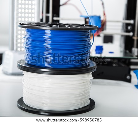 Personal 3d printer and abs or pla filament coils next to him..