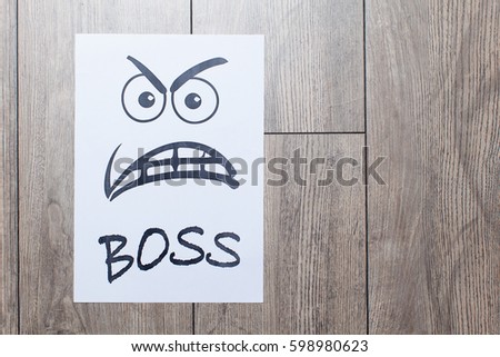  Evil painted boss face on a white paper on wood background