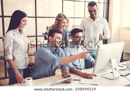 Beautiful business people are using computers and smiling while working in office Royalty-Free Stock Photo #598994519