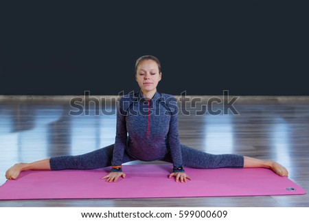 sport fitness woman, young healthy girl doing stretching exercises, full length portrait over blue background