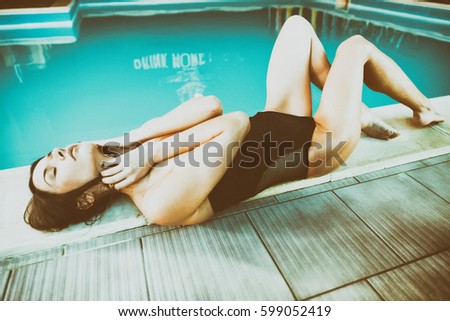Beautiful girl relaxing at swimming pool border.
