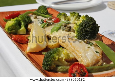 Pan fried fish fillet with a vegetable medley and lemon