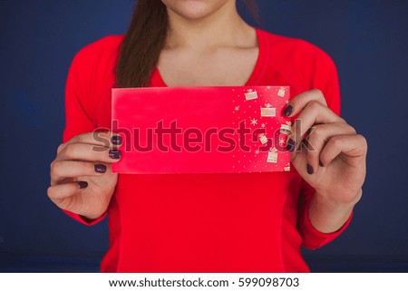 Woman in red t-shirt holding empty red card for advertising. Cropped photo. 