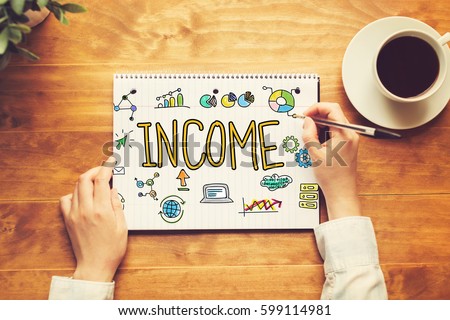 Income text with a person holding a pen on a wooden desk