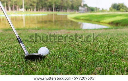Golf ball on white tee and golf club preparing to shot.