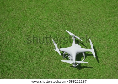 New drone with camera on green grass background, top view