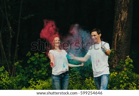 Portrait of happy couple playing in the park on holi colours festival