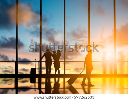 Young travelers dragging suitcases walked to travel abroad in the bus terminal would leave the country over blurred other travelers waiting plane and city at night interior with large windows. Royalty-Free Stock Photo #599262533