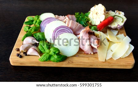  Sliced smoked bacon with onion, garlic, cheese and herbs  on wooden board 