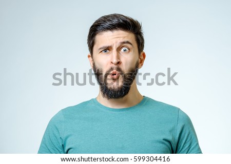 Portrait of young amazed man isolated on gray background Royalty-Free Stock Photo #599304416