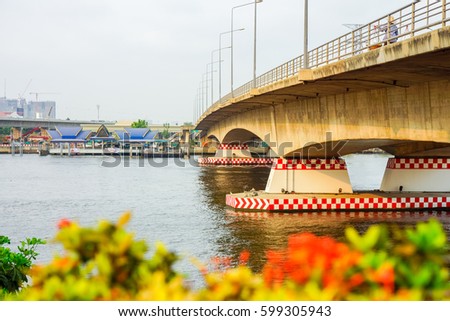 Pier and arch bridge over Chao Phraya river. It is in Bangkok, Thailand.