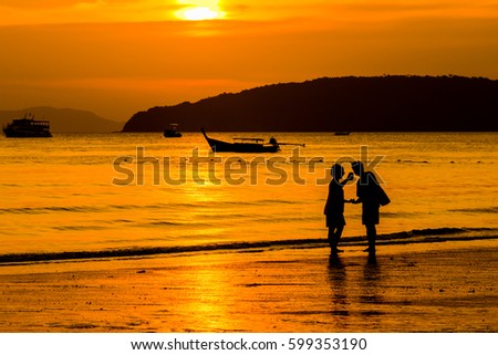 silhouette happy family taking photo on beach in the sunset time
