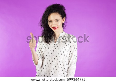 Happy young woman giving thumbs up .