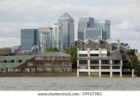 Canary Wharf viewed from the Thames at Poplar Homes in the Poplar district of East London with the tall towerblocks of Canary Wharf on the Isle of Dogs in London behind.