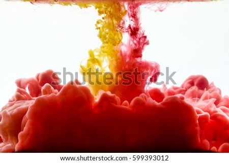 Multicolored swirling drop of ink in water creates abstract backgrounds
