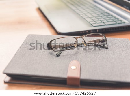 Office workplace with laptop and eyeglass on wood table