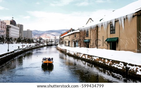 View of Otaru Canal in Winter season with signature tourist boat, Hokkaido - Japan. Royalty-Free Stock Photo #599434799