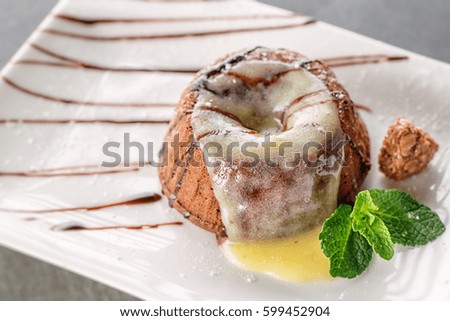 lava cake with vanilla pudding on top with mint leaf on white plate, product photography for patisserie