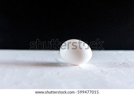 White egg on black background. Design, visual art, minimalism