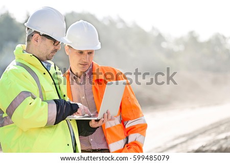 Supervisors using laptop at construction site Royalty-Free Stock Photo #599485079