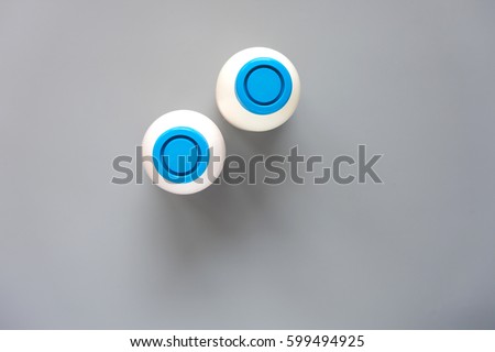 White plastic bottle mock up on grey background. Photo of two bottles with blue lids. View from above