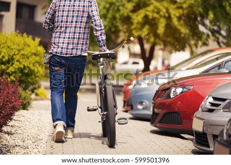 Man walking on pavement with bike