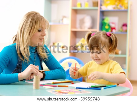 Teacher play with cute child in preschool