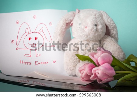 Fluffy funny Easter Bunny holding bunch of pink tulips and Happy Holidays letter with greeting text and his selfie on Tiffany blue background. Fashion colors 2017: Rosy Opalescence and Chlorine Sky