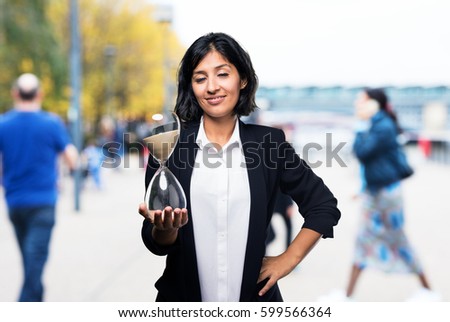 latin business woman holding a sand timer