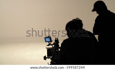Silhouette of working people or production film crew are making movie or shooting tv on-line content live show in studio with camera equipment set.